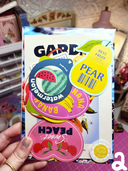 Colorful fruit-themed cards held by a person with a blurred background