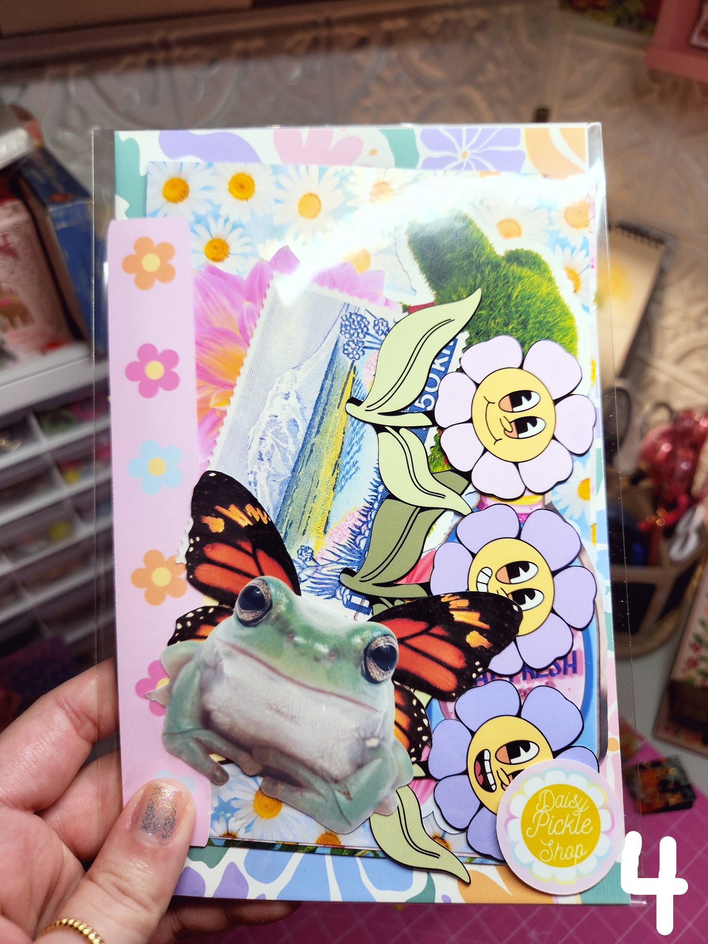Colorful card with cartoon flowers and butterflies held by a hand.