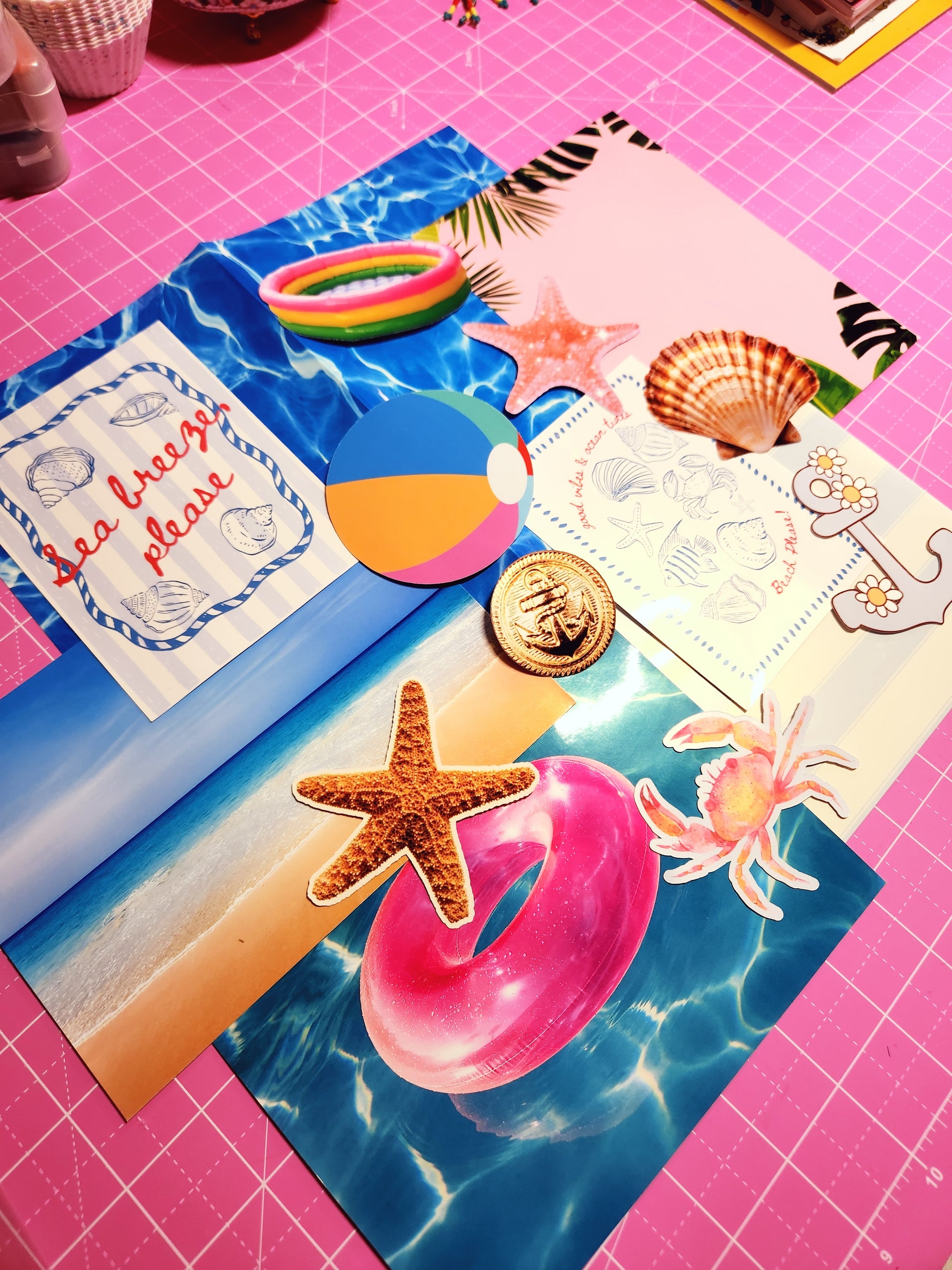 Colorful summer-themed cutout decorations on a pink cutting mat