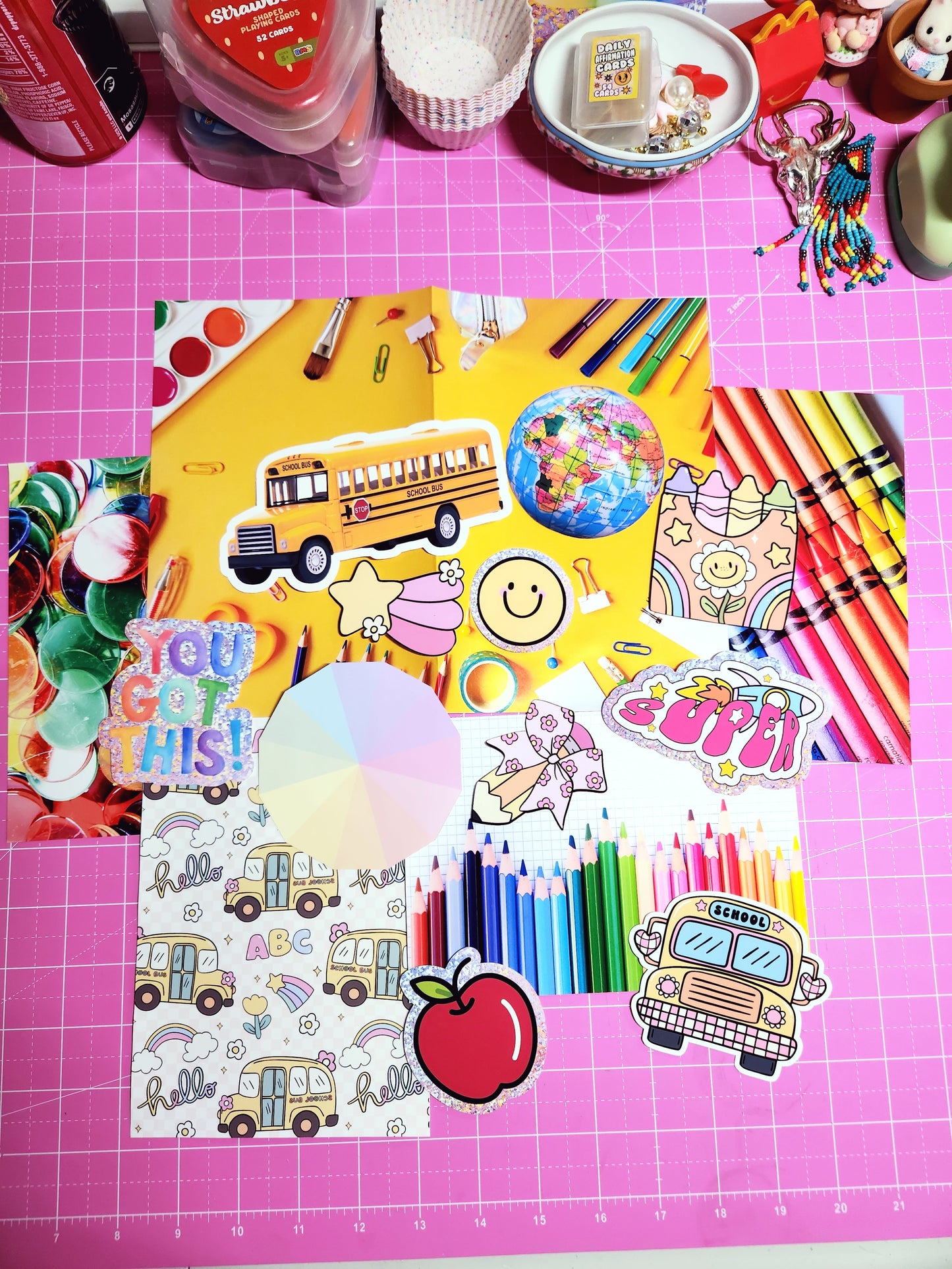 Colorful stationery items on a pink cutting mat