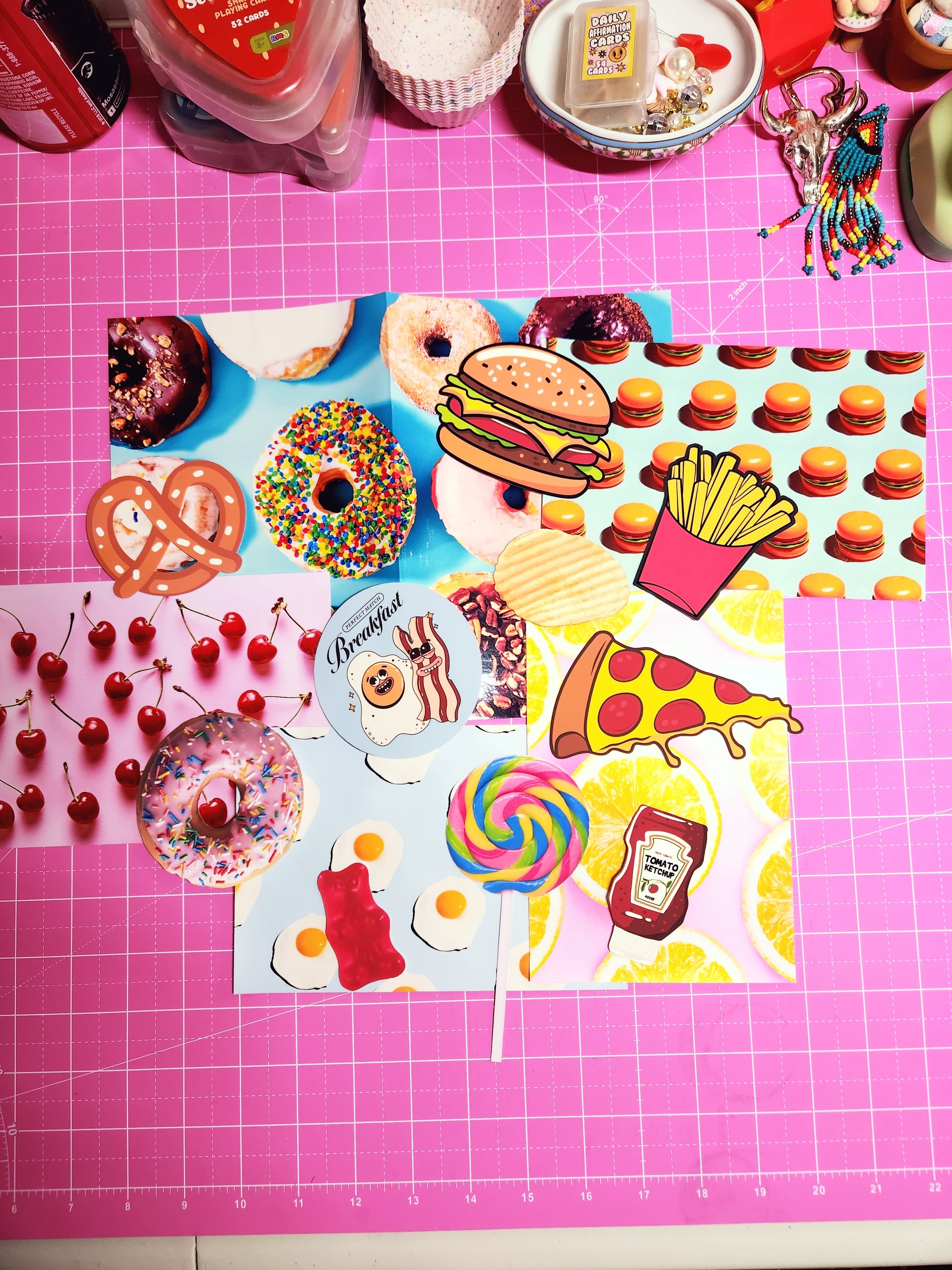 Colorful food-themed stickers on a pink cutting mat with grid lines.