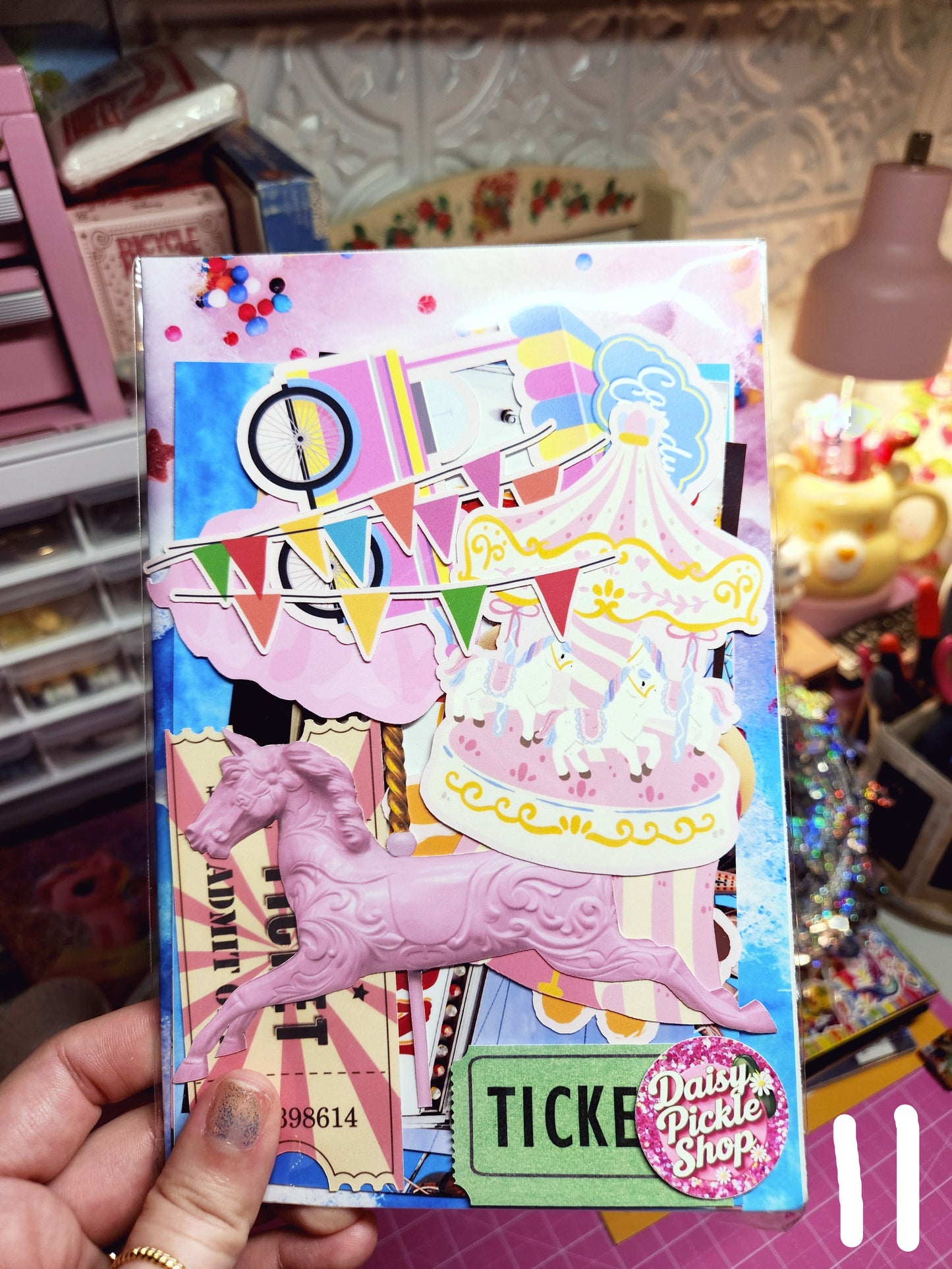 Colorful box with a pink unicorn design held by a hand against a blurred background