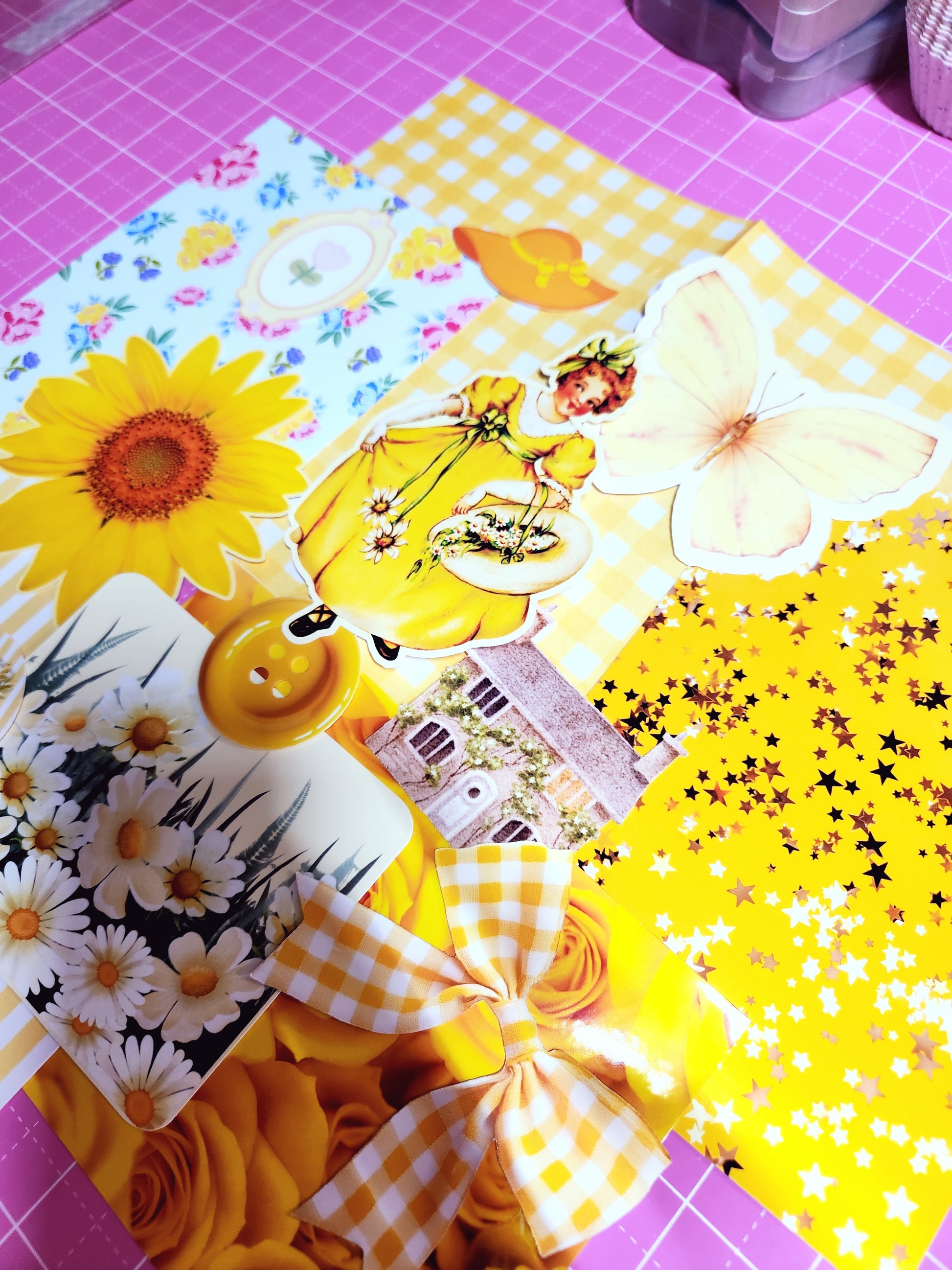 Collection of yellow-themed decorative items on a pink cutting mat