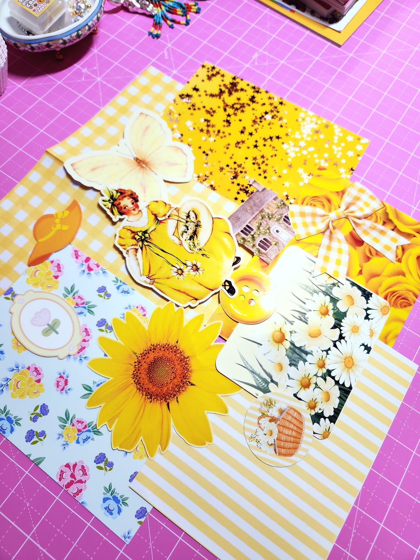 Collection of colorful stickers with floral designs on a pink cutting mat.