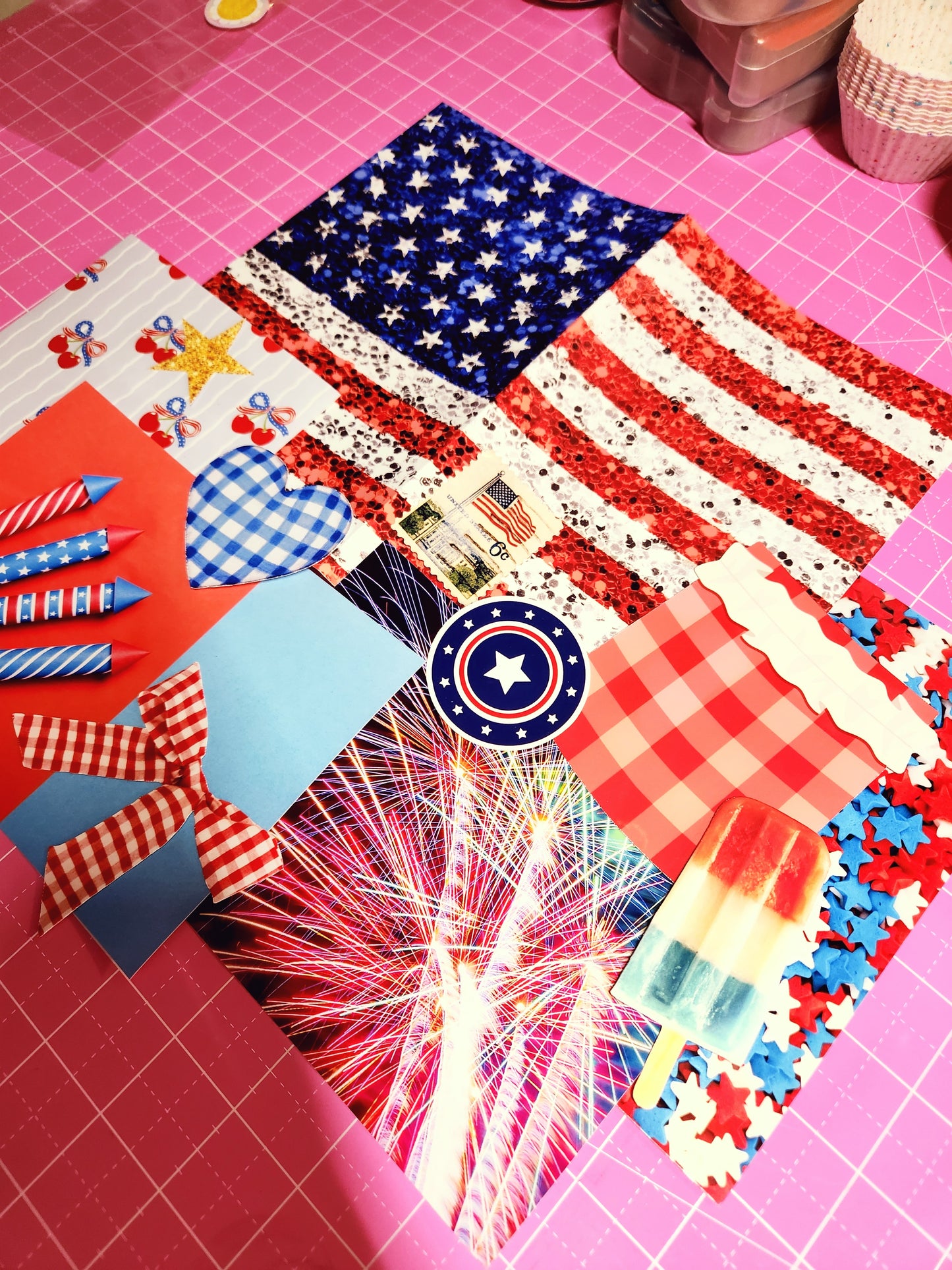 Collage of patriotic-themed paper with American flag, stars, and fireworks on a pink grid background.