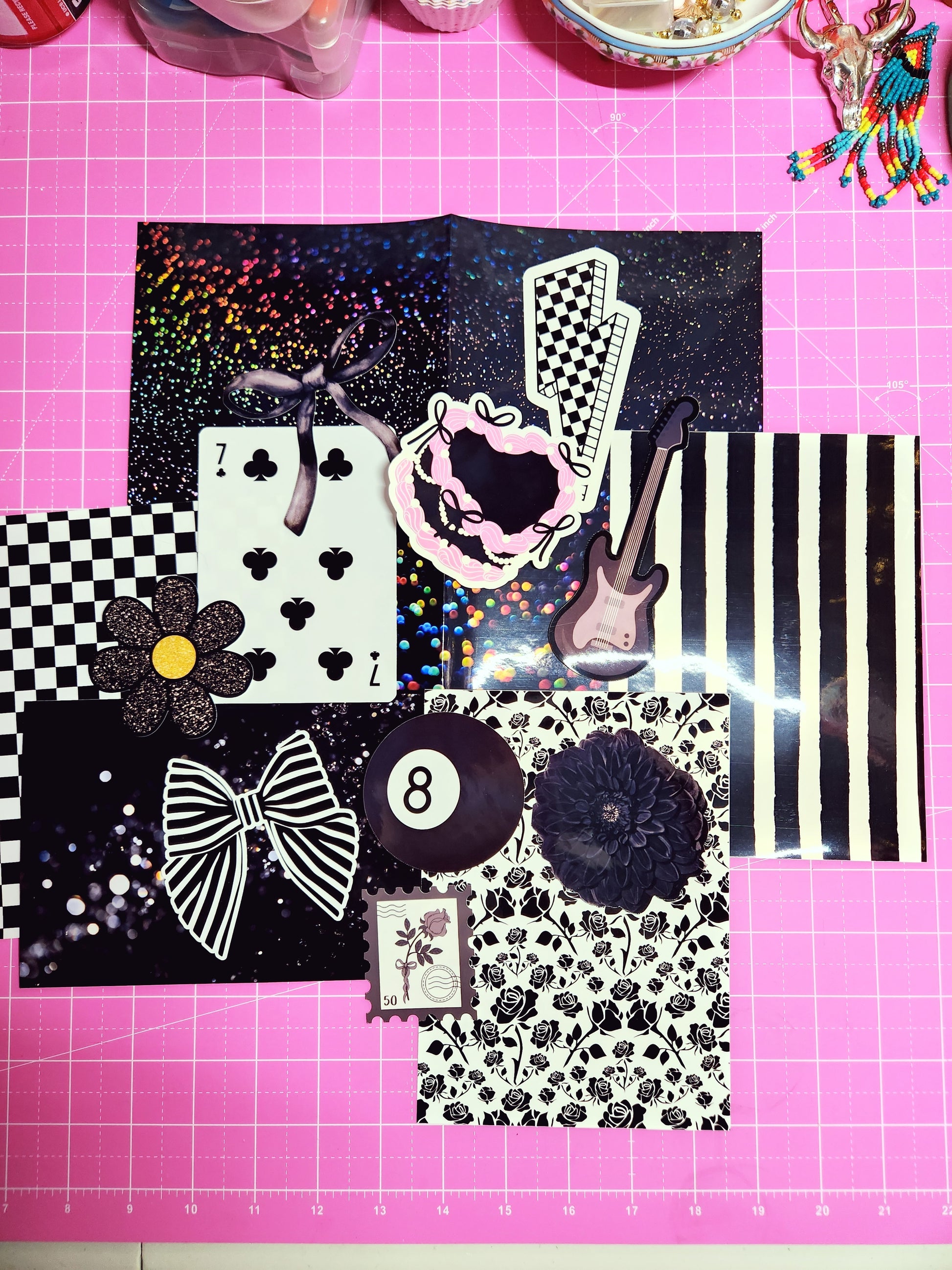 Collection of decorative paper pieces on a pink cutting mat with grid lines