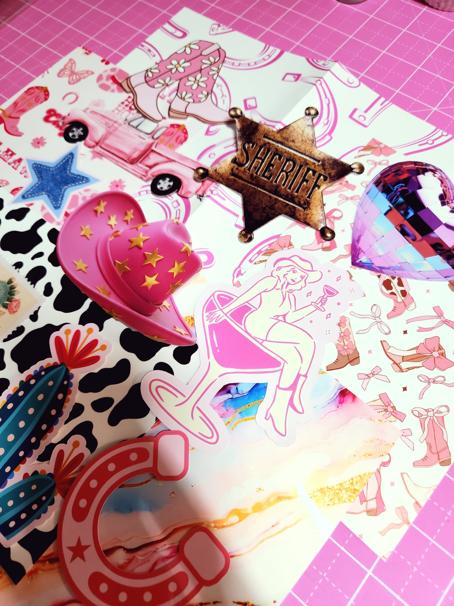 Collection of colorful stickers on a pink cutting mat with grid lines