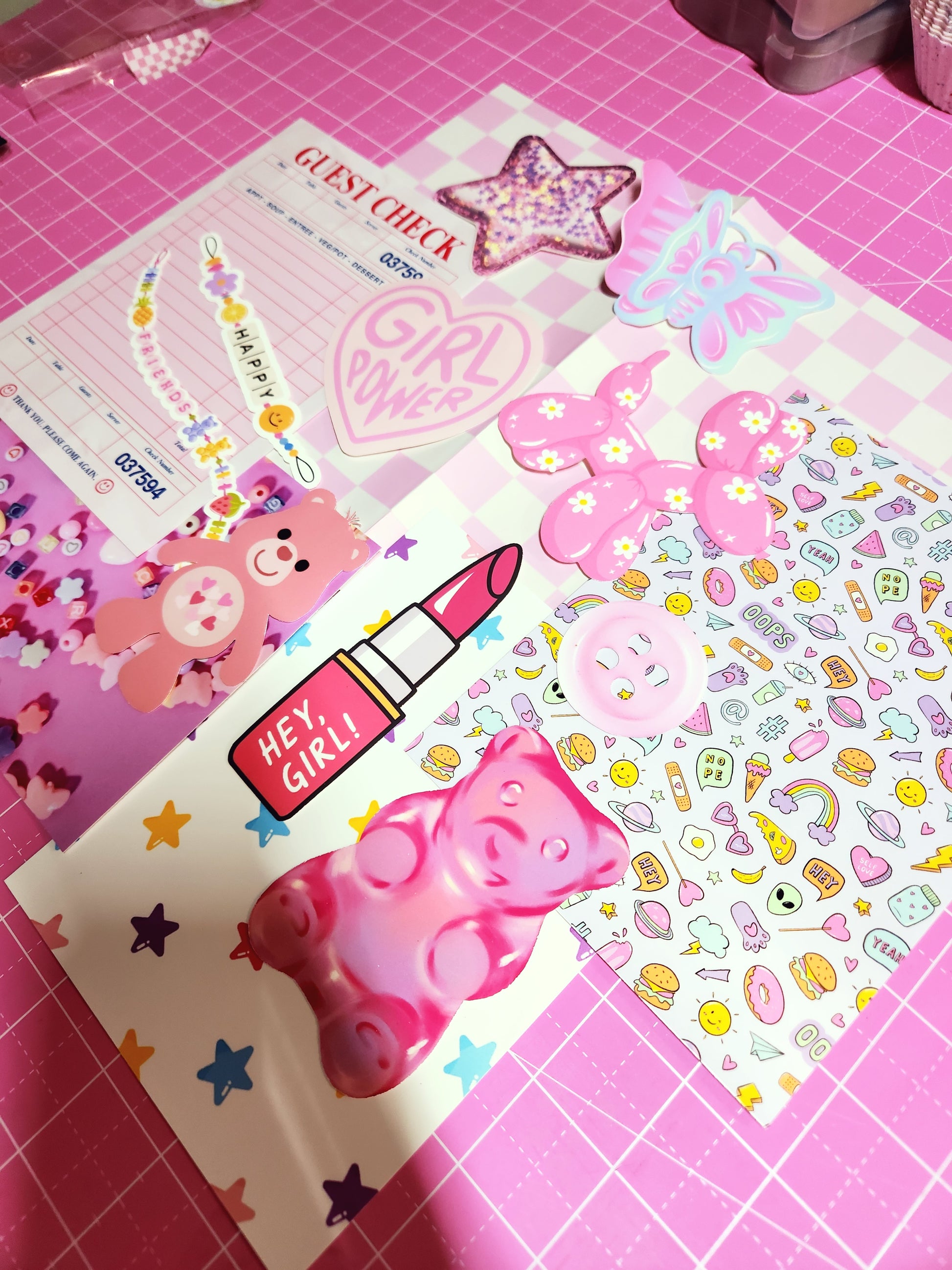 Sticker sheets with cute designs on a pink grid background