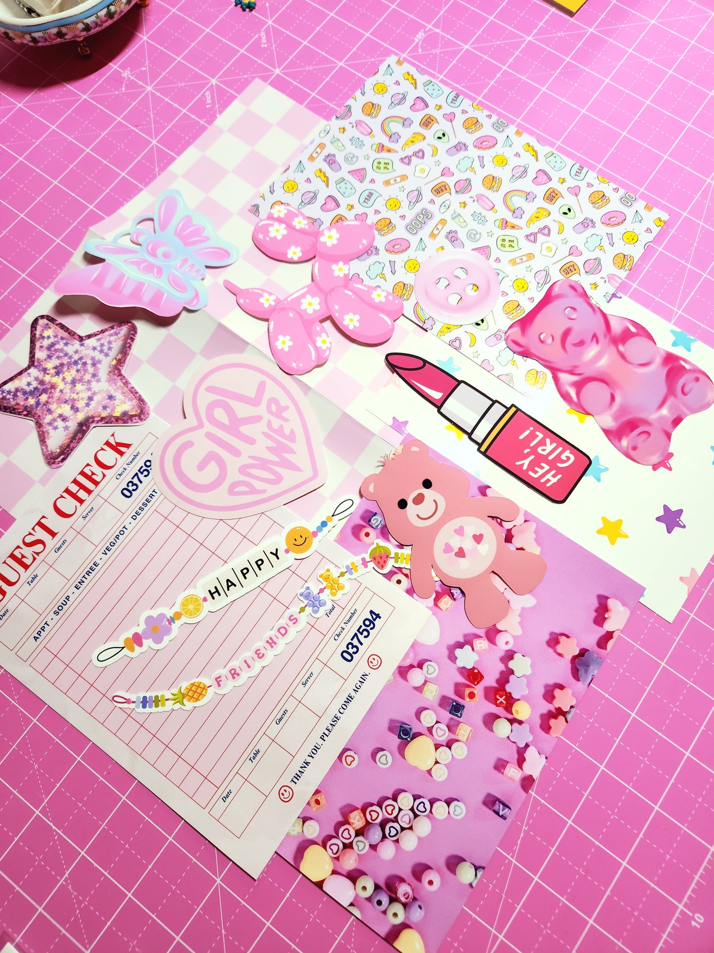 Collection of colorful stickers and a paper with text on a pink grid background
