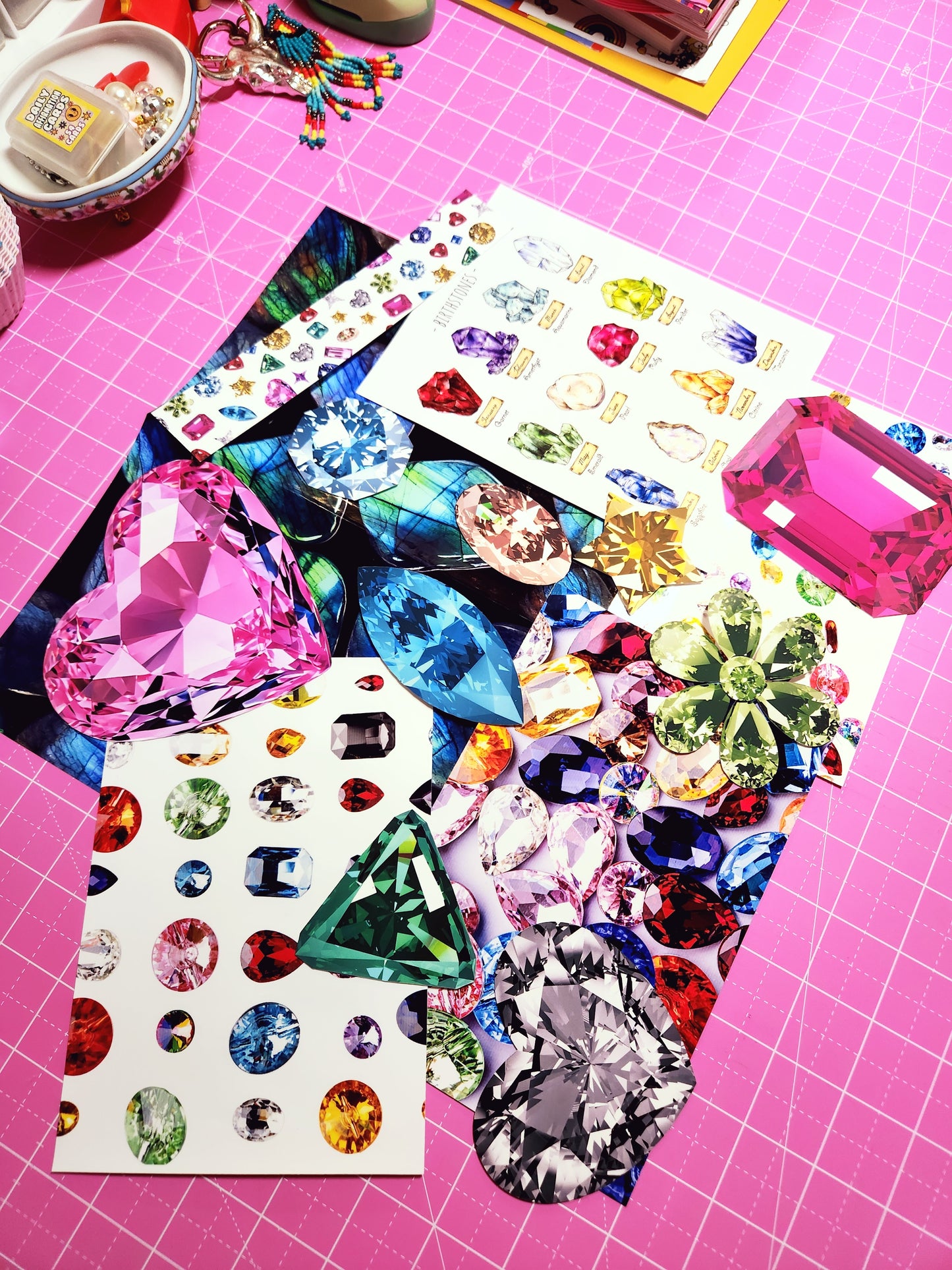 Colorful gemstone stickers on a pink grid background