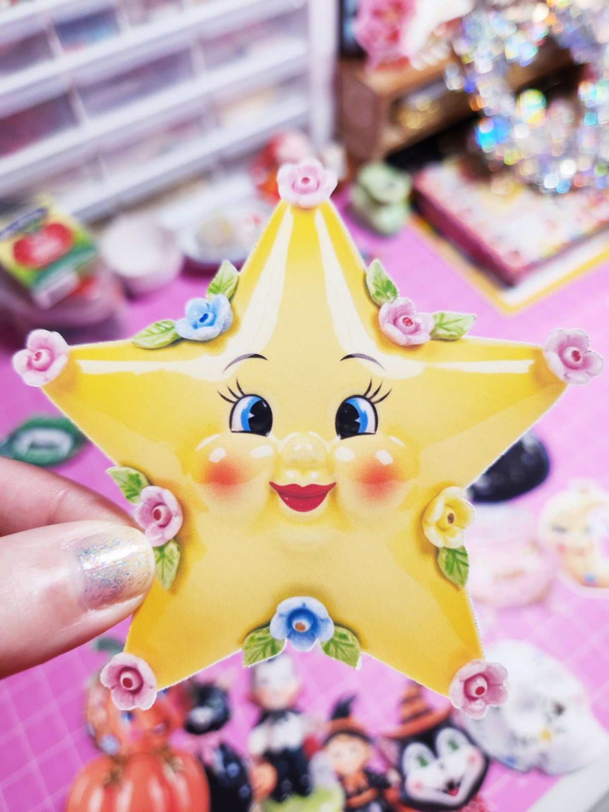Cartoon star-shaped sticker with facial features held by a hand on a colorful background