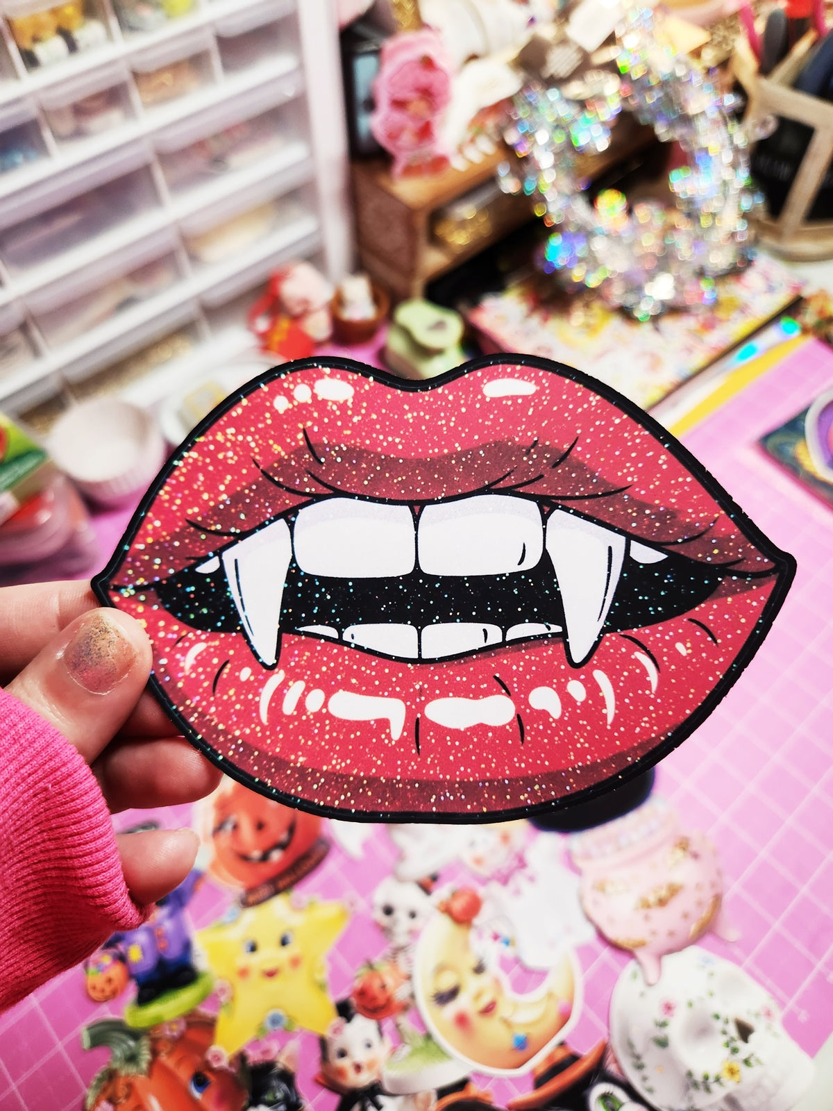 Vampire lips patch held by a person with a colorful background