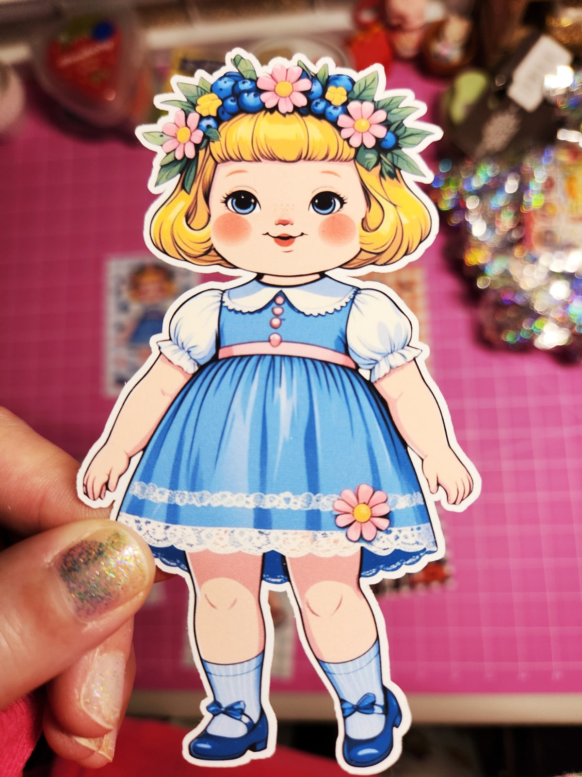 Cartoon character in a blue dress with flowers on a pink background
