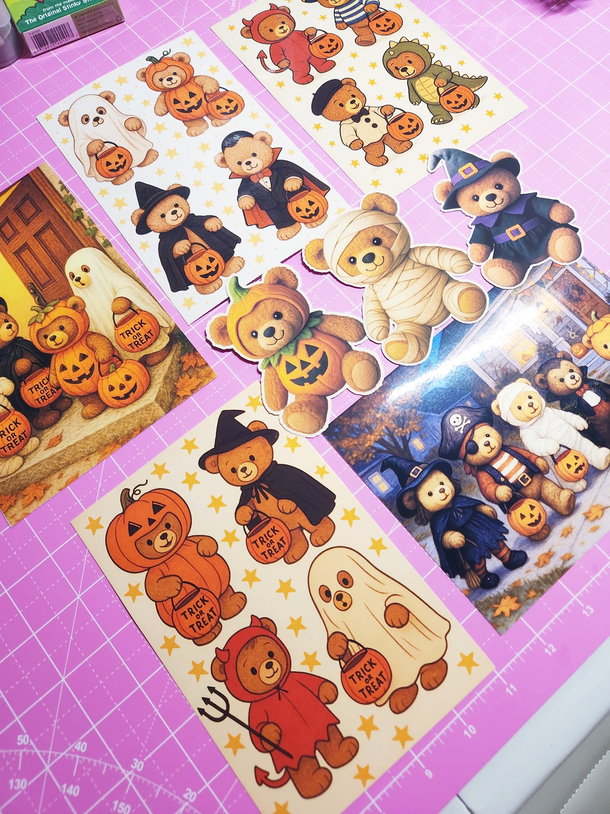 Halloween-themed stickers featuring teddy bears on a pink cutting mat.