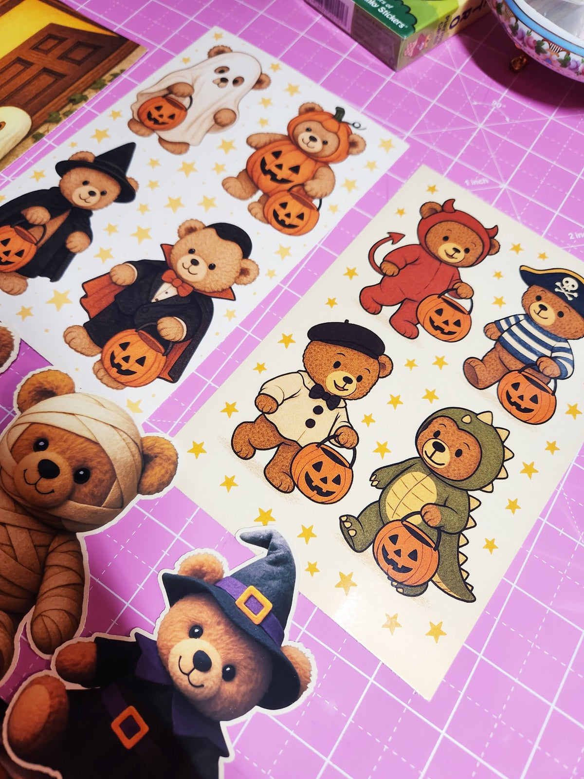 Halloween-themed bear stickers on a pink cutting mat