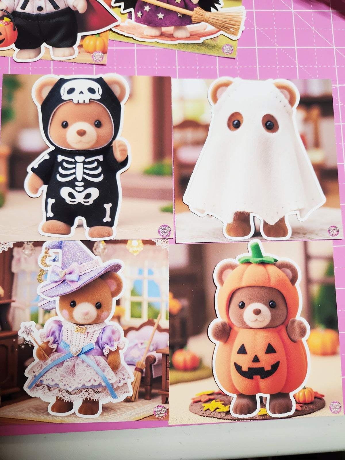 Four teddy bears in Halloween costumes on a pink grid background