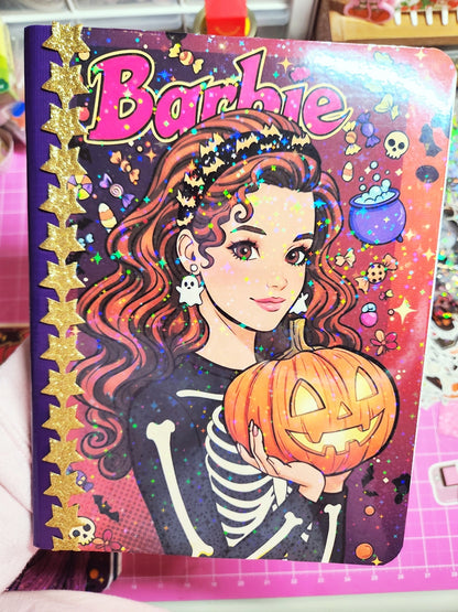 Barbie Halloween-themed notebook with a pumpkin and skeleton design on a colorful background.