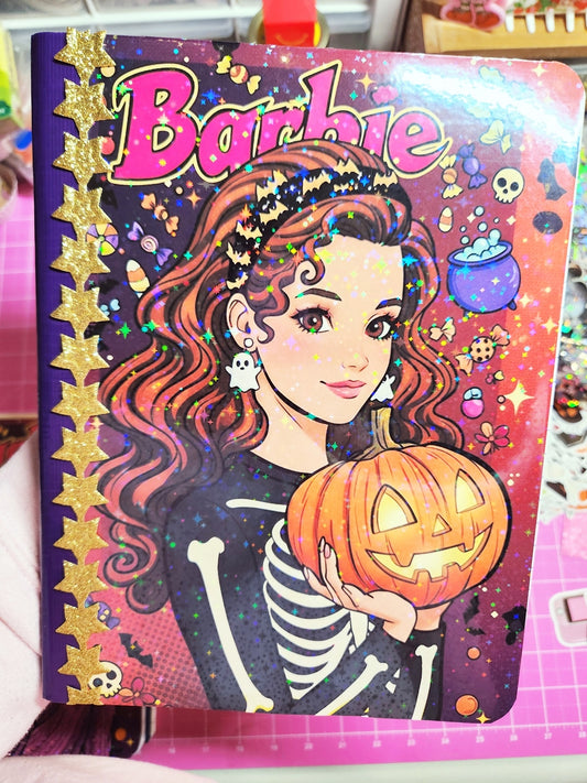 Barbie Halloween-themed notebook with a pumpkin and skeleton design on a colorful background.