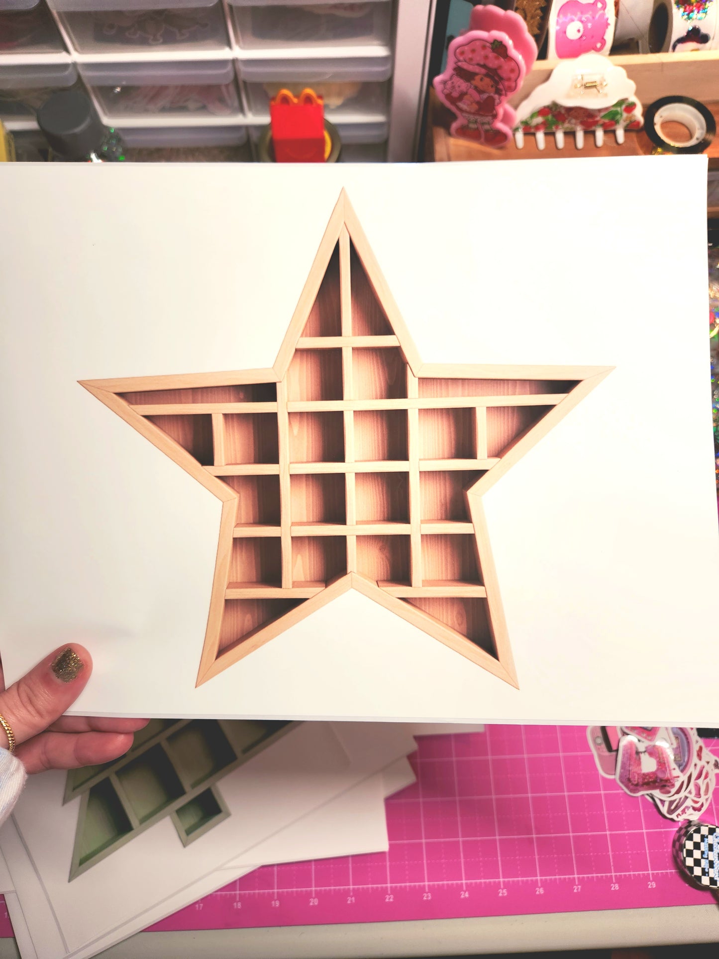 Star-shaped wooden organizer held by a hand on a crafting table.