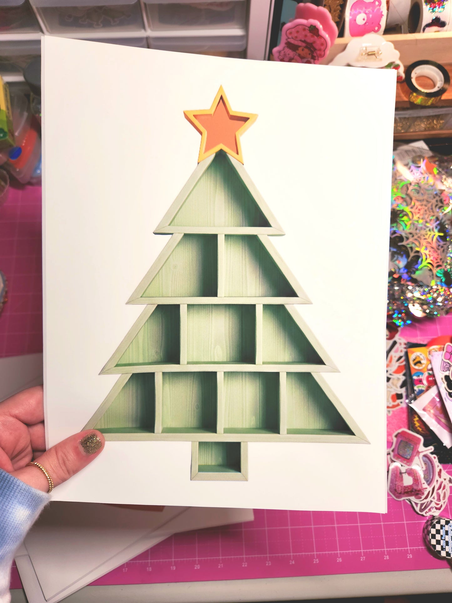 Card with a Christmas tree design and star on a pink cutting mat.