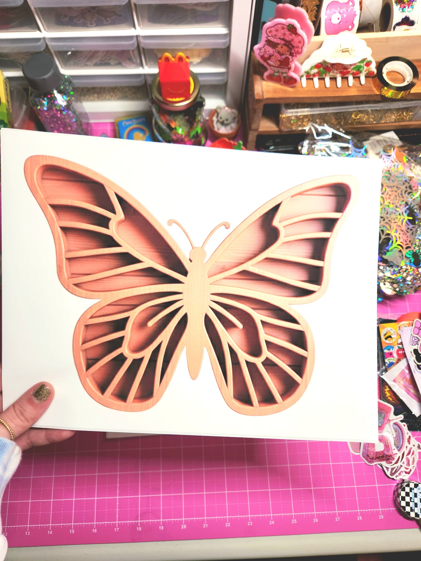 Butterfly-shaped cutout on a white card with a pink cutting mat in the background