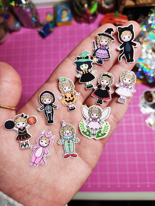 Hand holding colorful costume stickers on a pink grid background