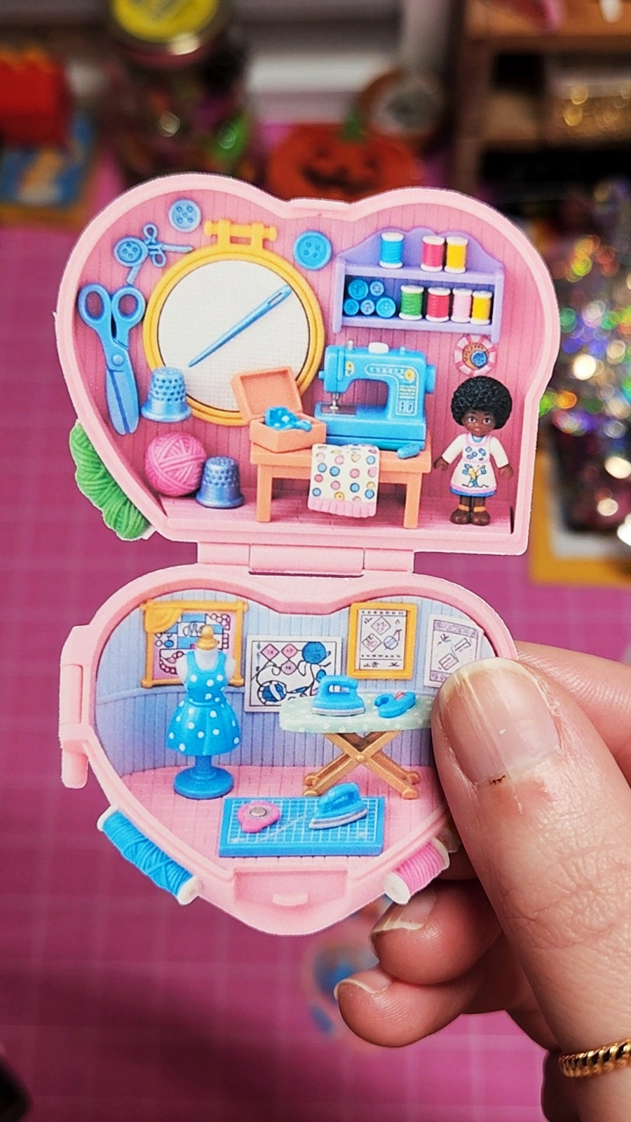 Toy jewelry box with a miniature room inside, held by a hand.