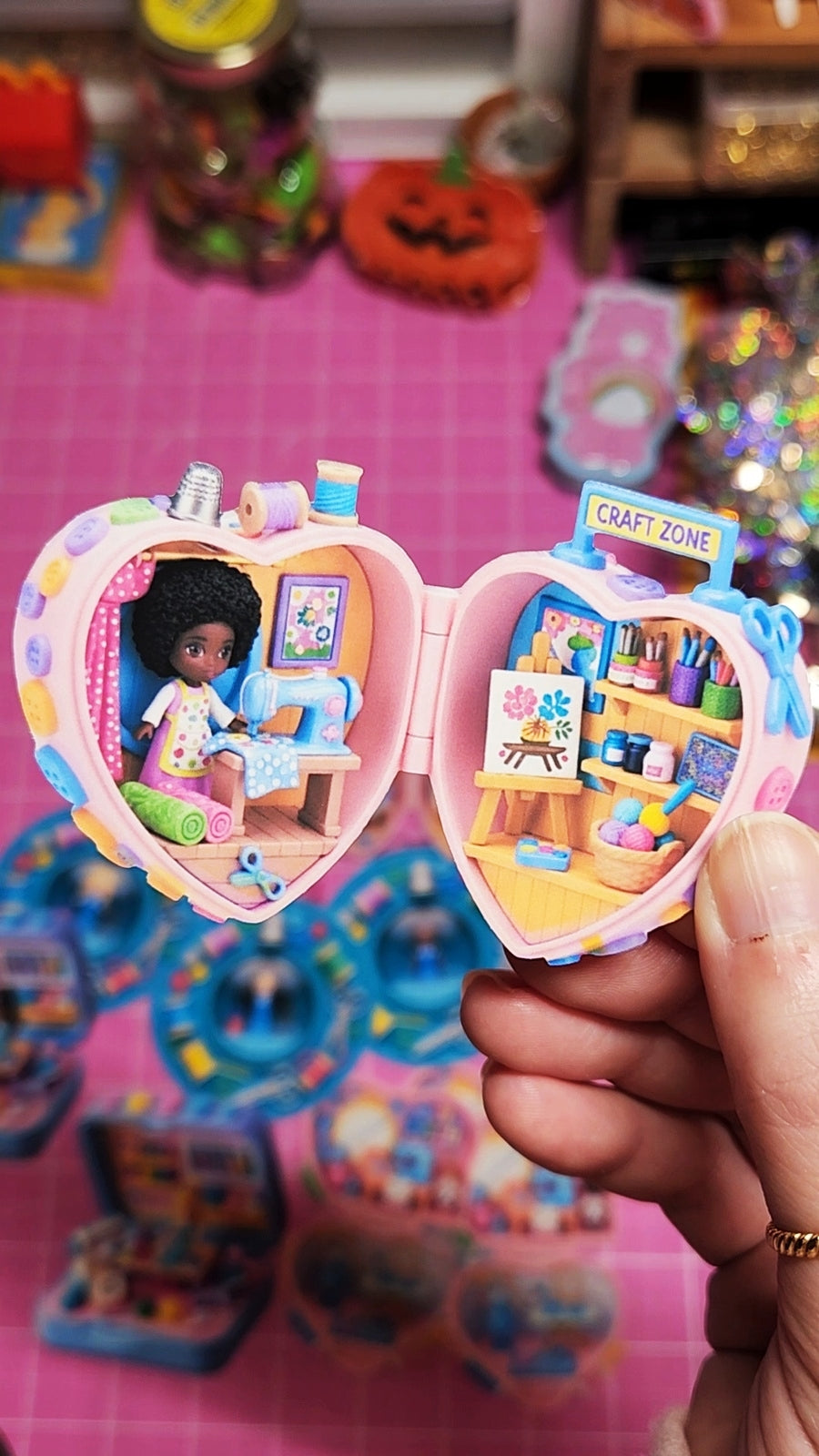 Toy with a small doll inside, held by a hand on a colorful background