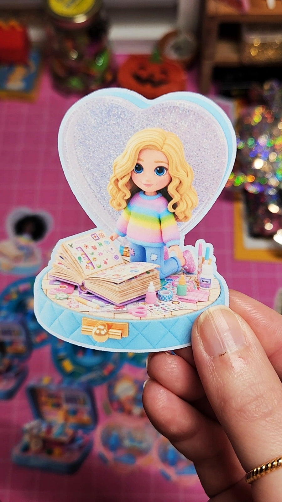 Small figurine with a heart-shaped background held by a hand on a colorful background