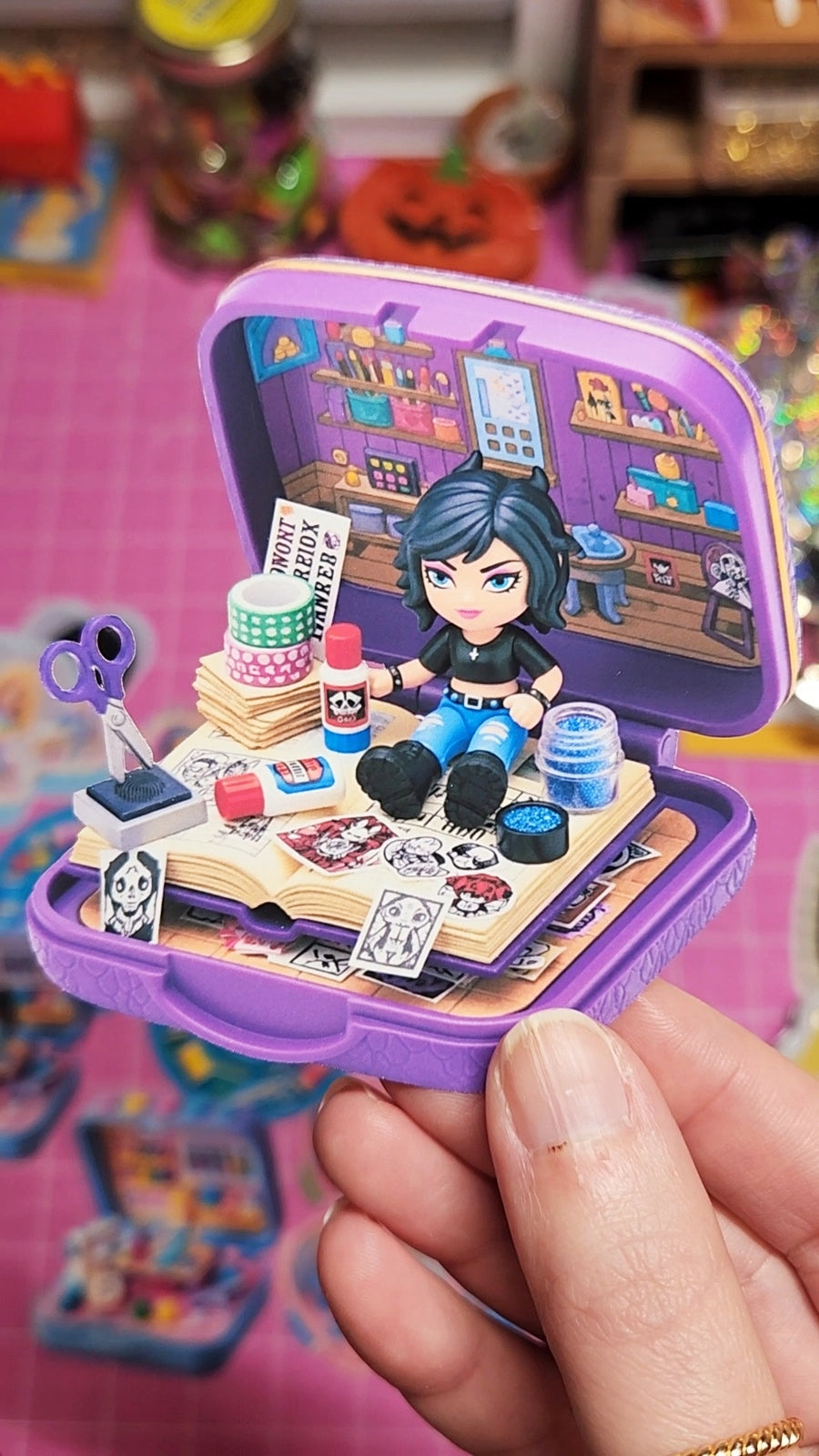 Toy makeup set in a purple case held by a hand on a colorful background