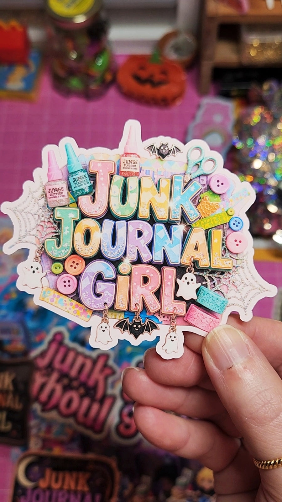 Colorful 'Junk Journal Girl' sticker held by a hand with a colorful background.