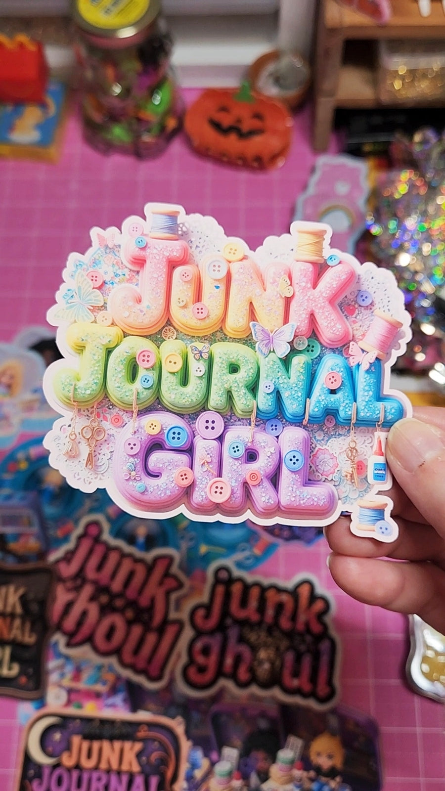 Colorful 'Junk Journal Girl' sticker held in front of a colorful background with 'Junk Journal' books.