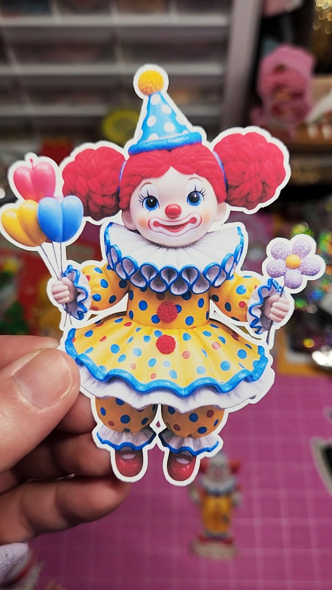 Colorful clown figurine held by a hand with a blurred background