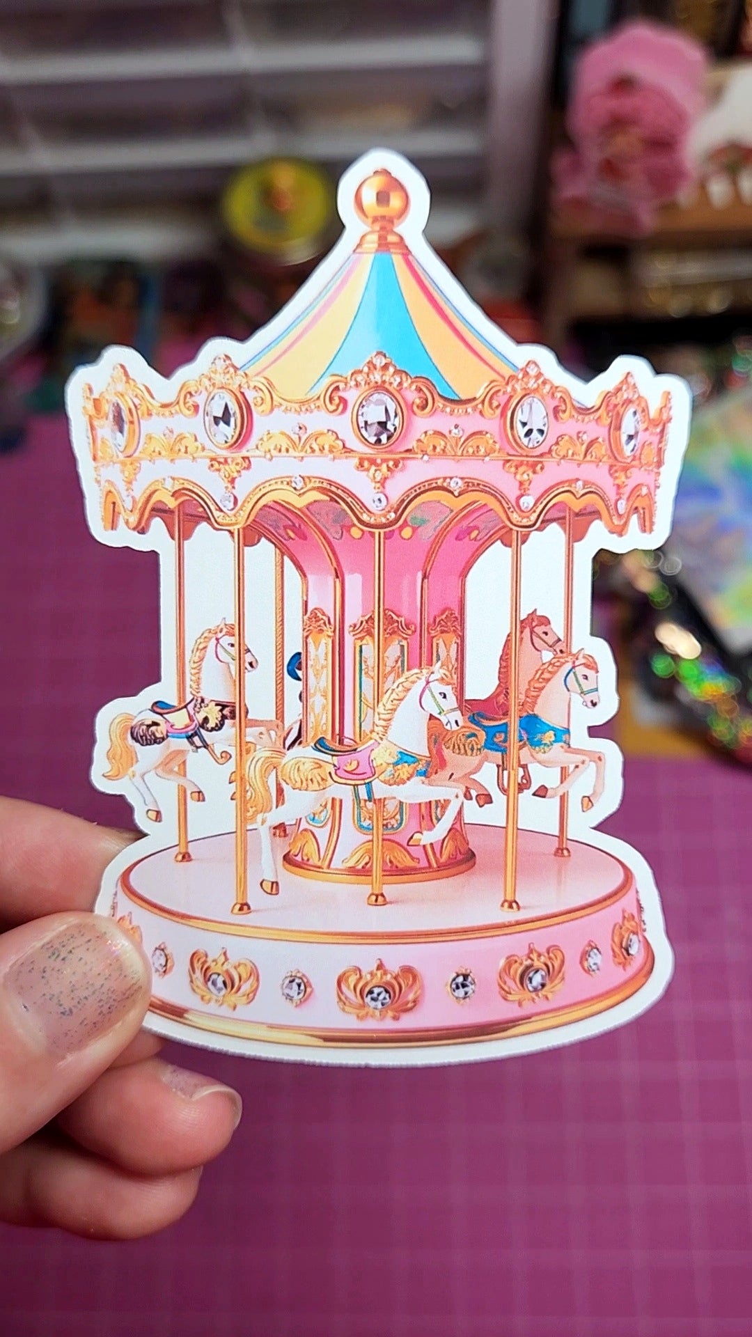Decorative sticker of a carousel held by a hand with a blurred background