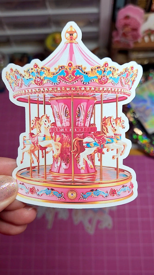 Colorful carousel sticker held by a hand on a pink background