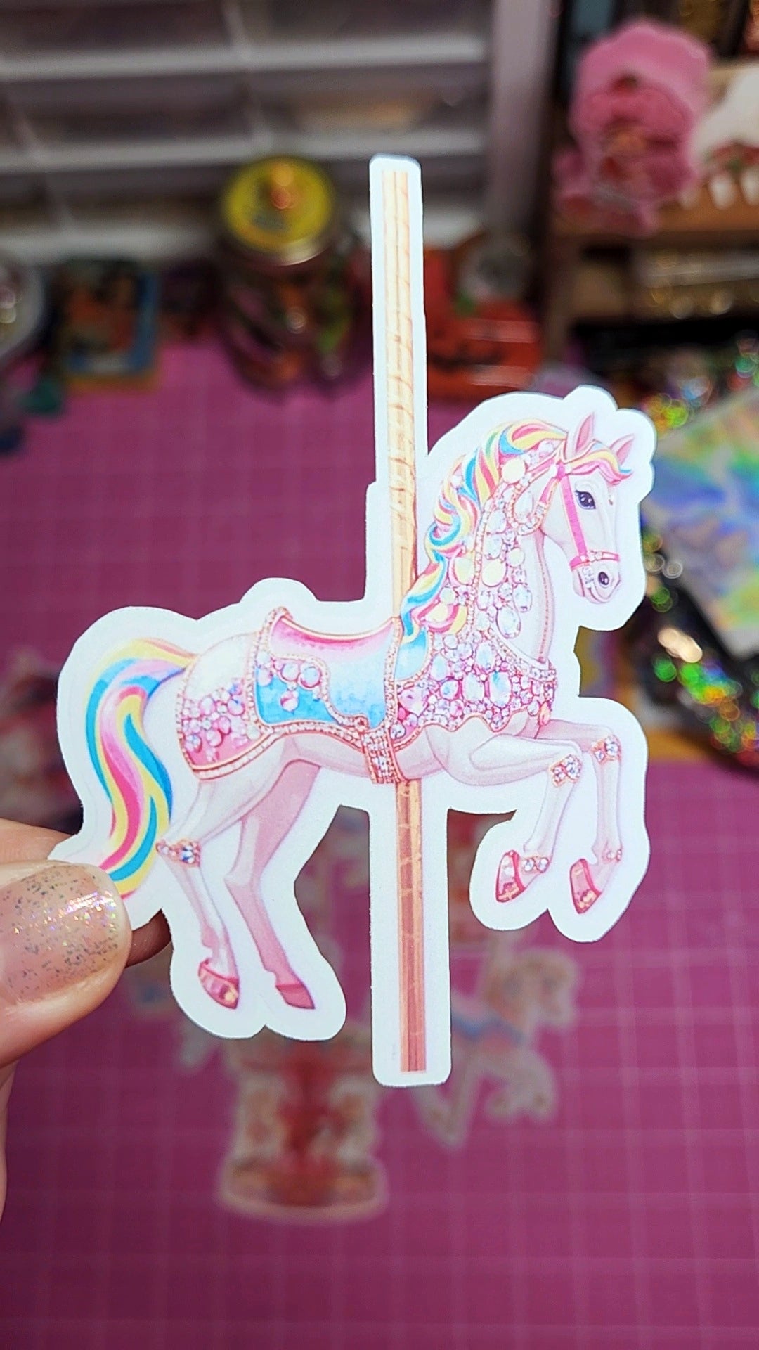Colorful unicorn sticker held by a hand with a blurred store background