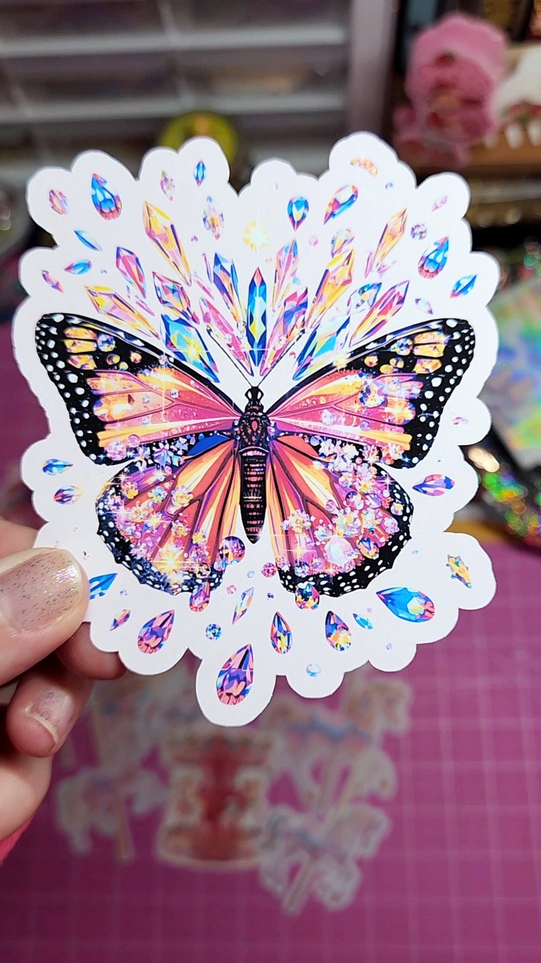 Colorful butterfly sticker held by a hand with a blurred background