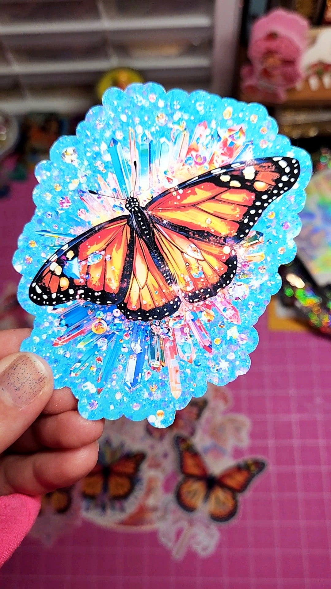 Colorful butterfly sticker held by a hand with a blurred background