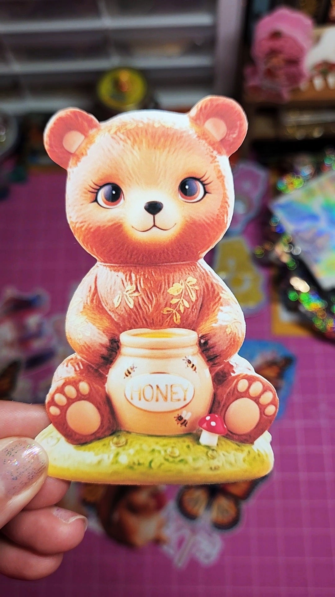 Cute teddy bear figurine holding a honey jar with a blurred background