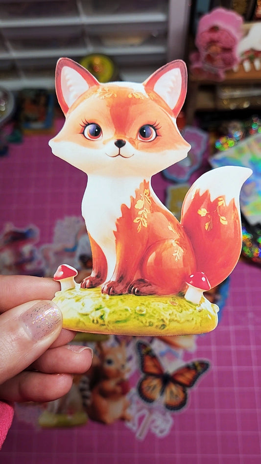 Cartoon fox figurine held by a hand with a colorful background