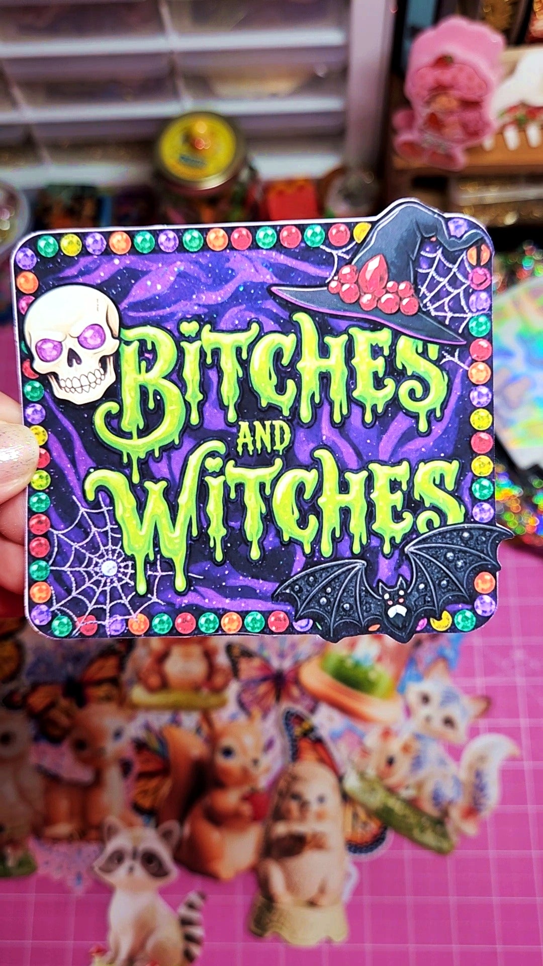 Halloween-themed card with colorful border and text 'Bitches and Witches' held by a person.