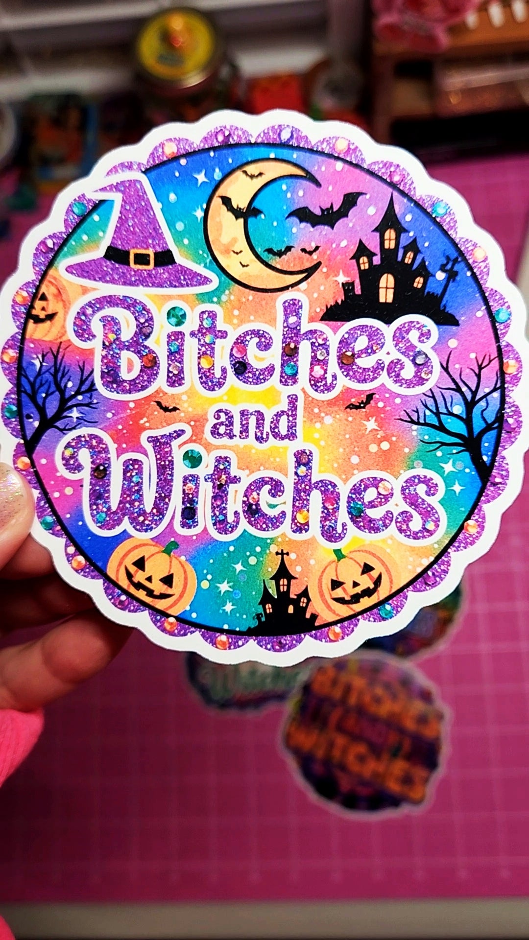 Colorful Halloween-themed sticker with 'Bitches and Witches' text on a pink background.