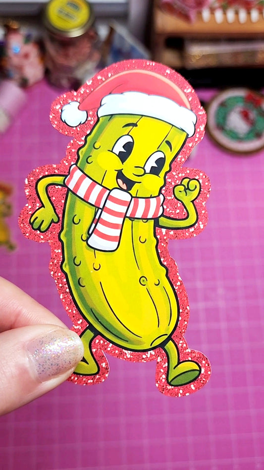 Cartoon pickle with a red hat and striped scarf on a pink background