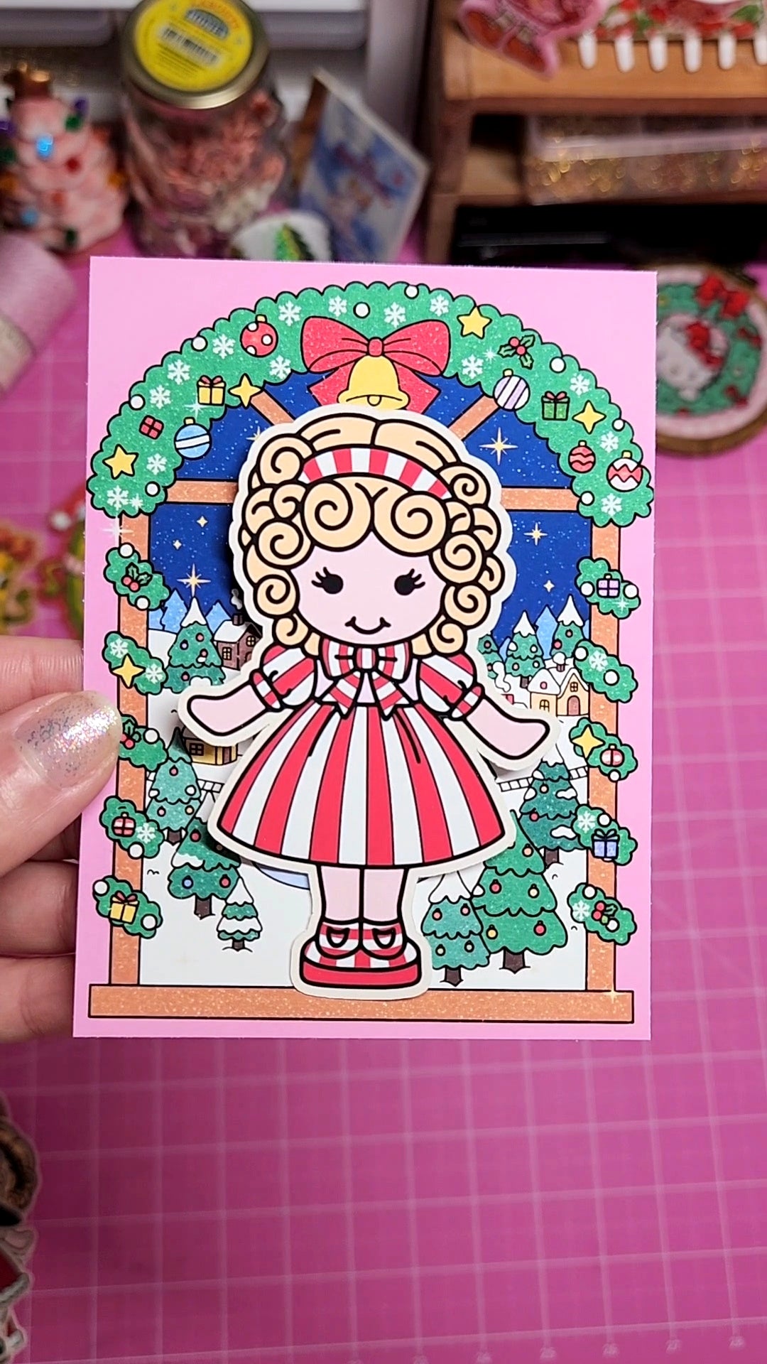 Colorful illustration of a cartoon character on a pink card with decorative border.