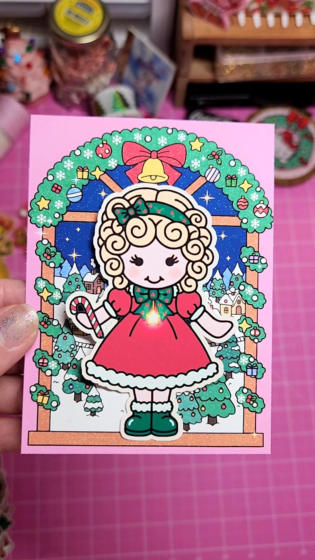 Illustrated character in a festive setting held against a pink background