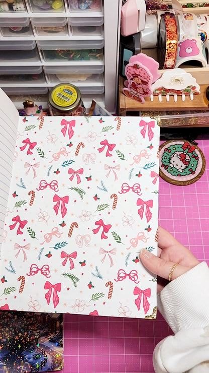 Sheet of paper with festive bow and candy pattern held by a hand in a craft room.