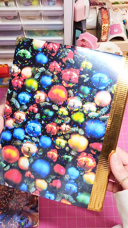 Colorful fabric with a pattern of multicolored balls held by hands on a pink surface.