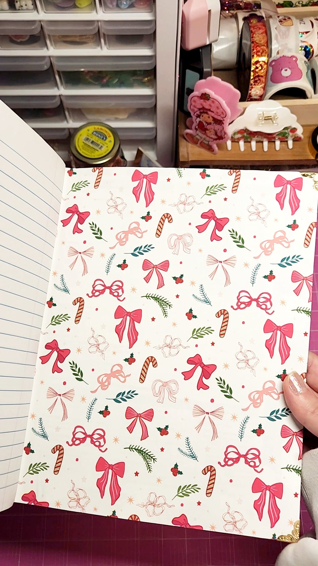 Notebook with festive design featuring bows and candy canes on a white background.