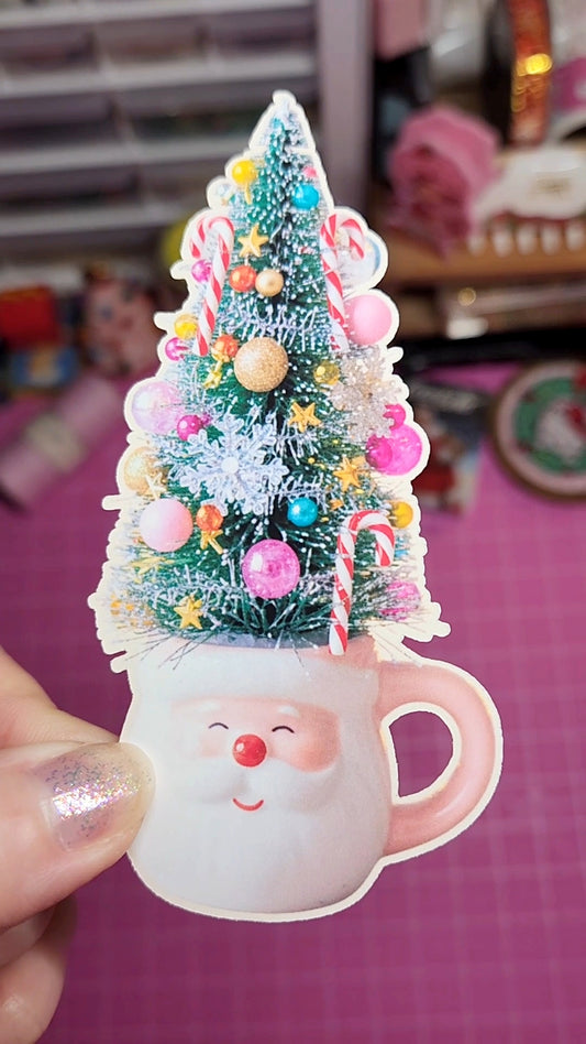 Decorative Christmas tree in a Santa mug with colorful ornaments on a blurred background