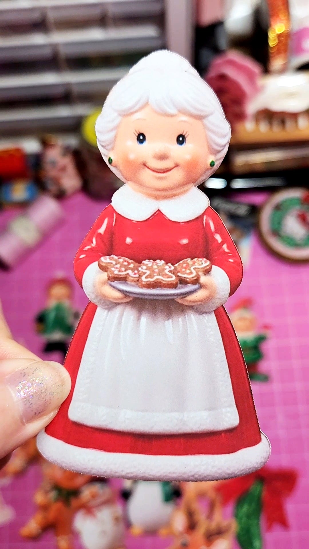 Figurine of a character in a red dress holding cookies against a blurred background